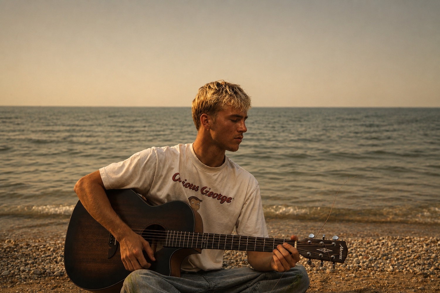 A musician with a guitar beside the water.